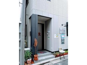 una puerta de un edificio con plantas y una silla en Tokyo stay Hut SARI - Vacation STAY 27239v, en Tokio