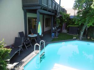 a swimming pool with chairs and a table next to a building at Mühlenwörth Relax Quartier in Tauberbischofsheim