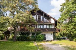 ein Haus mit zwei Hunden davor in der Unterkunft Flatista Homes - Garden House in München