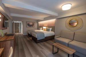 a hotel room with a bed and a couch at Riu Plaza The Gresham Dublin in Dublin