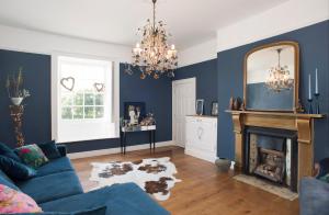 uma sala de estar azul com lareira e espelho em Rame Barton Guest House and Pottery em Cawsand