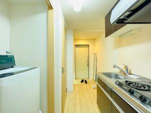 Una pequeña cocina con fregadero y estufa. en Nishishinjuku 902, en Tokio