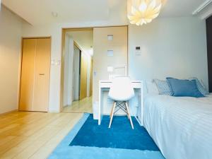 1 dormitorio con escritorio, 1 cama y 1 silla en Nishishinjuku 902, en Tokio