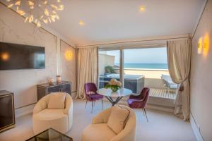 a living room with a table and chairs and a window at Grand Hotel Principe Di Piemonte in Viareggio