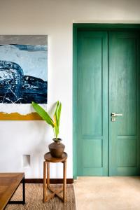 a green door in a room with a potted plant at Kayaam House in Tangalle