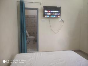 Habitación hospitalaria con cama y TV en la pared en Braj Waterpark & Resort, en Kannauj