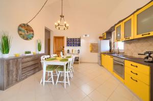 a kitchen with yellow cabinets and a table and chairs at Apartment TOP in Kornić