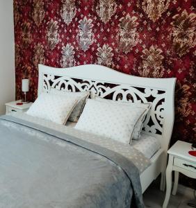 a bedroom with a white bed and a red wall at Carla's Apart Palas-Hala Centrala 1 Bedroom, airport shuttle in Iaşi