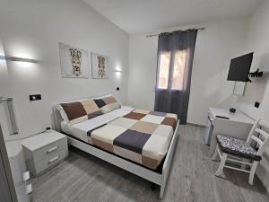 - une chambre avec un lit, un bureau et une chaise dans l'établissement FronteMare Locazione Turistica, à Porto Empedocle