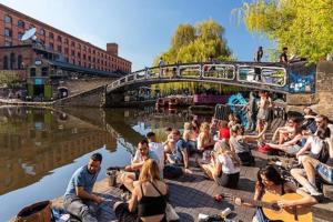 a group of people sitting on the ground by the water at Entire 2-bedroom Flat in Camden in London