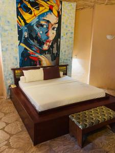 sypialnia z łóżkiem z obrazem na ścianie w obiekcie Bamboo Village Resort w mieście Kololi