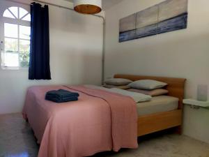 ein Schlafzimmer mit einem Bett mit einer rosa Decke in der Unterkunft Wohnung Sabina in Agüimes