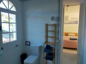 ein Bad mit einem WC und ein Schlafzimmer mit einem Bett in der Unterkunft Wohnung Sabina in Agüimes