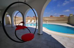 a swing in front of a swimming pool at Astonis in Belek
