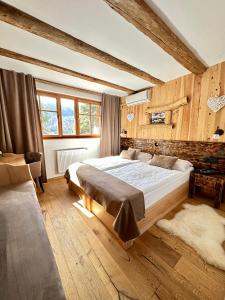 ブレッドにあるRibno Alpine Hotelの大きなベッドと木製の壁が備わるベッドルーム1室が備わります。