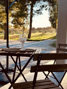 un tavolo con un bicchiere di vino seduto sopra di Agricampeggio La Piaggia - Agriturismo a Piombino
