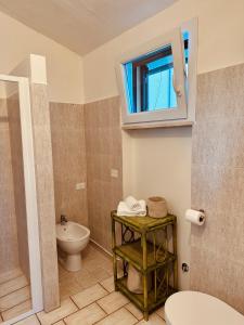 a bathroom with a toilet and a window at Agricampeggio La Piaggia - Agriturismo in Piombino