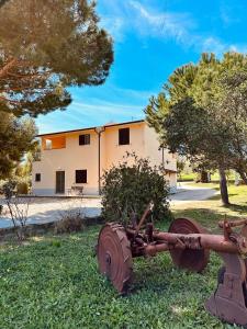 an old tractor in the grass in front of a building at Agricampeggio La Piaggia - Agriturismo in Piombino +21 photos