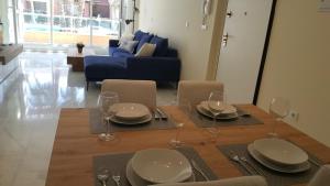 mesa de comedor con sillas y sofá azul en Luxury Apartment Los Olivos HK - 99 HDA Golf Resort, en Fuente Alamo