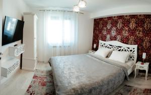a bedroom with a large bed and a red wall at Carla's Apart Palas-Hala Centrala 1 Bedroom, airport shuttle in Iaşi