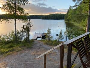 un muelle en un lago con un barco en el agua en Myllyjärven mökki, en Fiskars