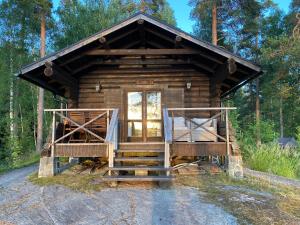 Cabaña de madera en el bosque con porche en Myllyjärven mökki, en Fiskars