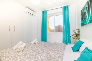 1 dormitorio con 1 cama con cortinas azules y ventana en Erisa 55 by IVI Real Estate en Torremolinos