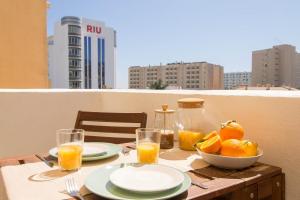 una mesa con un bol de fruta y vasos de zumo de naranja en Erisa 55 by IVI Real Estate, en Torremolinos