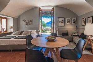 - une chambre avec un lit, une table et des chaises dans l'établissement Atelier dell'Artista by Wonderful Italy, à Varenna