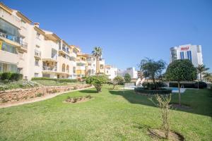 a park in front of a large apartment building at Erisa 55 by IVI Real Estate in Torremolinos