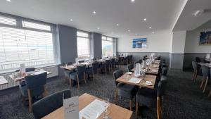 a dining room with tables and chairs and windows at Anchor Head Hotel in Weston-super-Mare