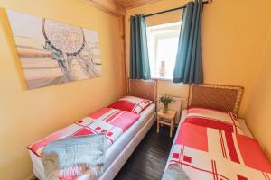 two twin beds in a room with a window at Pension zur Postmeile in Bad Belzig