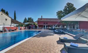 uma piscina com cadeiras e um guarda-sol ao lado de um edifício em Hotel Villa Donat em Sveti Filip i Jakov