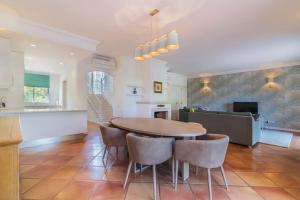 a kitchen and dining room with a table and chairs at Moradia Geminada com 2 Quartos Quinta do Lago in Quinta do Lago