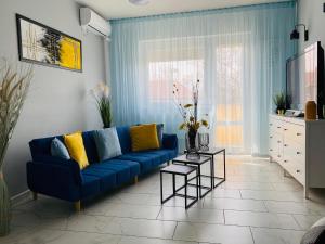 a living room with a blue couch and a table at Daylight City Center in Szeged