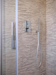 a shower with a hose attached to a wall at Casa Ierardi - Appartamento Meina in Meina