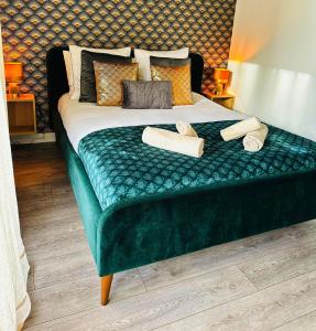- un lit avec un banc vert et 2 serviettes dans l'établissement Charme, balcon, parking, piscine, tramway, Netflix, à Mérignac