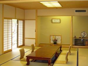 - un salon avec une table et des chaises en bois dans l'établissement Rokugatsu-no-Mori Auberge, à Sano