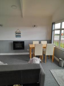 a living room with a table and chairs and a fireplace at Perfect chalet to relax in k4 in Mablethorpe