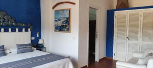 ポルト・チェルボにあるValesmeralda Boutique Roomsの青と白のベッドルーム(ベッド1台、椅子付)