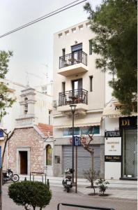 ein weißes Gebäude mit Balkon darüber in der Unterkunft Soho #1 Luxurious apartment in Saint Nicolas in Agios Nikolaos