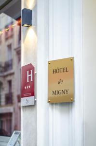 a sign on a building that reads hotel be mighty at Hotel Migny Opéra Montmartre in Paris