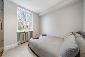 a white bedroom with a bed and a window at Modern 4 Bedroom Townhouse with Cinema Room in the heart of London SE1 in London