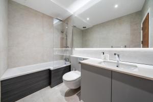 a bathroom with a sink and a toilet and a tub at Modern 4 Bedroom Townhouse with Cinema Room in the heart of London SE1 in London
