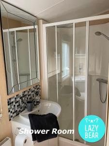 a bathroom with a shower room with a sink and a mirror at Lazy Bear, 25 Arne View in Poole