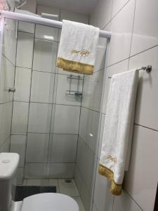 a bathroom with white towels and a toilet at Flat JK 102 in Juazeiro do Norte +18 photos