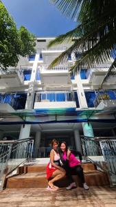 Dos mujeres posan frente a un edificio. en Aundanao Oasis Beach en Samal