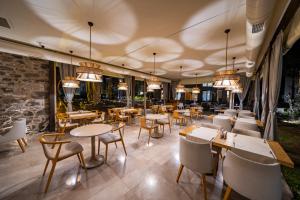 un ristorante con tavoli, sedie e lampadari a braccio di Helis Suites Bitez a Bodrum City