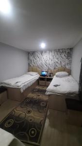 a small room with two beds and a television at Tatev Boutique Cottage in Tatʼev