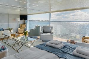 a bedroom on a yacht with a view of the water at Domki na wodzie - HT Houseboats - with sauna, jacuzzi massage chair in Mielno